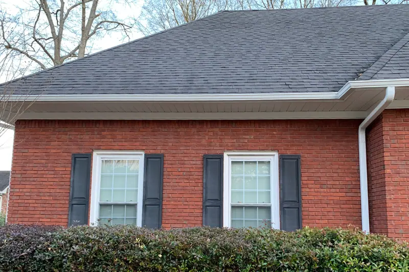 Brick home with a dark shingle roof, white gutter and downspout, a Mosqueda Construction job near Birmingham, AL