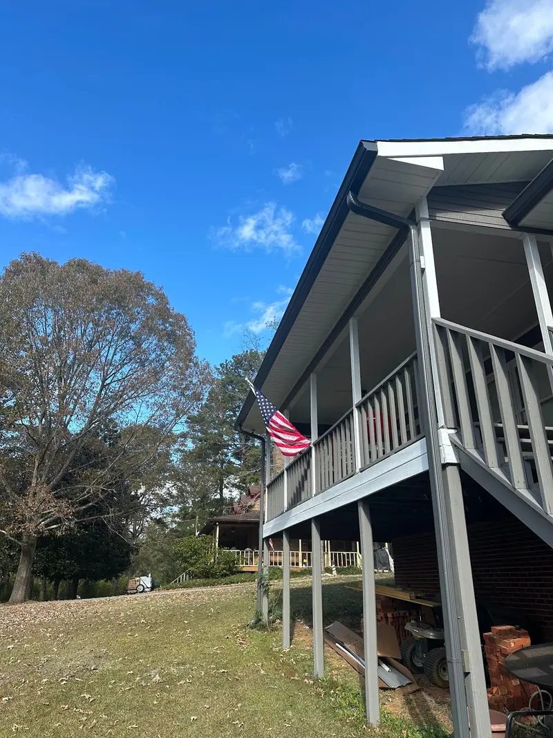 Raised back porch with new dark gutters and a downspout, a Mosqueda Construction job in the Birmingham area